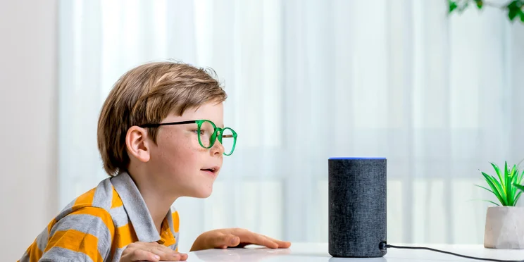 Child speaking to Amazon Echo Alexa-enabled smart speaker illustrating Alexa skills concept.