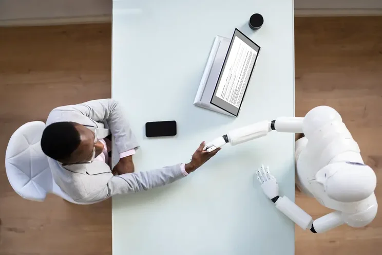 Professional man shaking the hands of a robot
