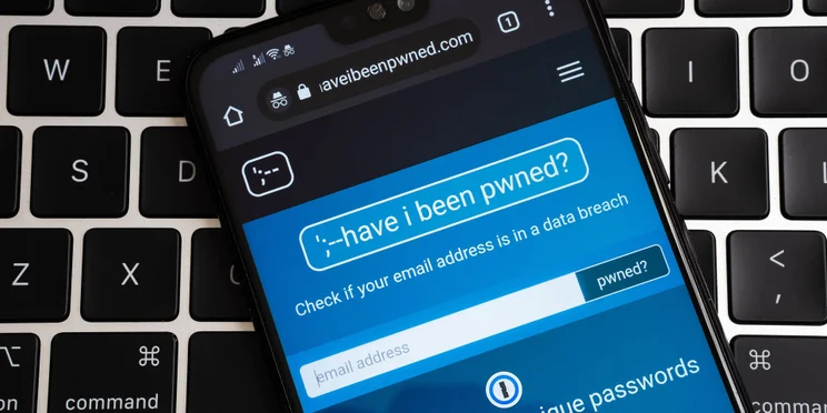 Data breach notification site "Have I been pwned" open on smartphone against keyboard background