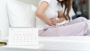 Woman in bed on her period