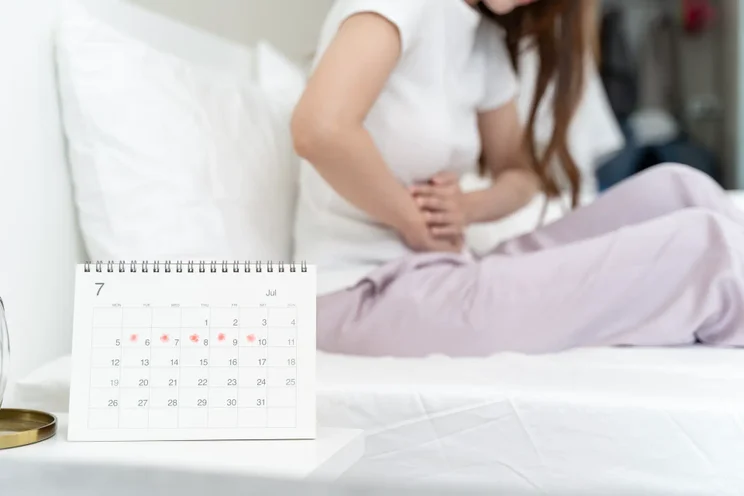 Woman in bed on her period