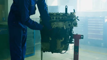 A worker completes preventative maintenance on an engine.