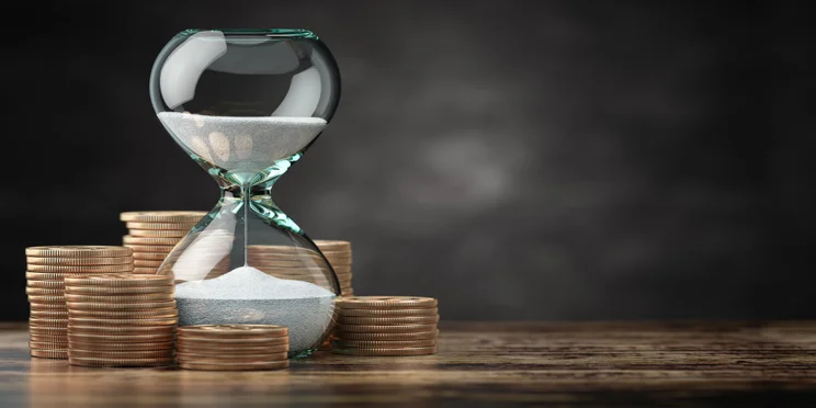 hourglass surrounded by money