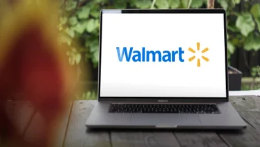 Walmart logo open on laptop screen on porch of house of remote worker