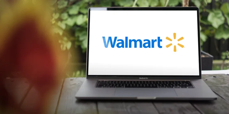 Walmart logo open on laptop screen on porch of house of remote worker