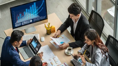 Image of HR team meeting to discuss KPIs shown on Mac style AIO computer