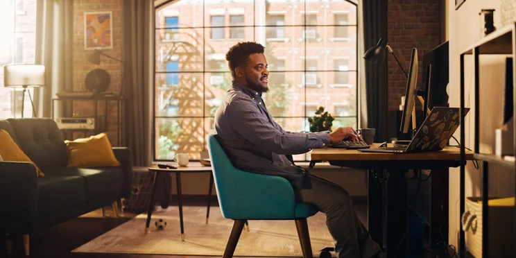 Happy man working productively from home in sunny stylish apartment