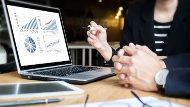 Charts showing asset management KPIs on laptop