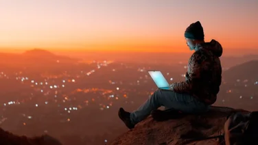 Digital nomad sitting on a rock