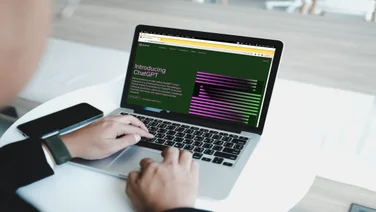 Professional using ChatGPT on laptop