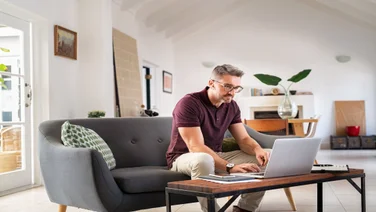 Man working remotely on his sofa