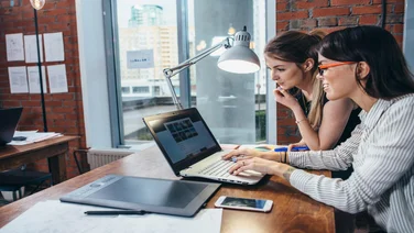 Two people using a website builder