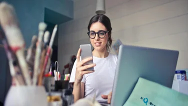 Person with a laptop and a phone