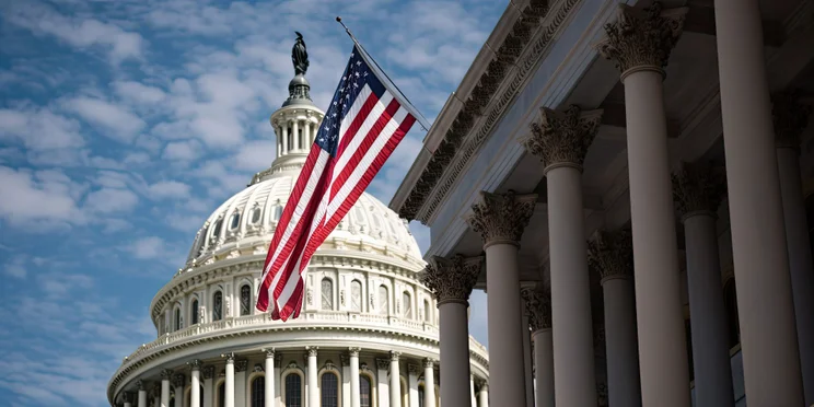 A photo of the US Capitol in front of the American flag.