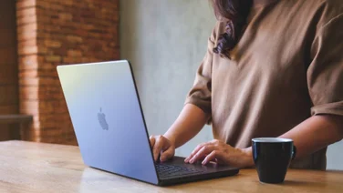 A person works remotely using an Apple laptop.