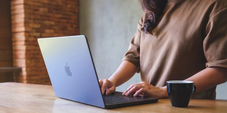 A person works remotely using an Apple laptop.