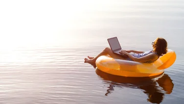 Woman works from the comfort of an inflatable lilo