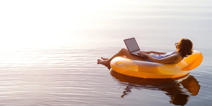 Woman works from the comfort of an inflatable lilo