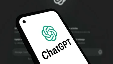 chatgpt logo on a phone screen, with the desktop version in the background.