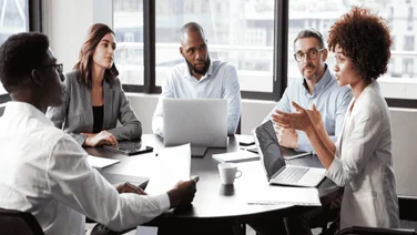 A team of people having a conversation in an office.
