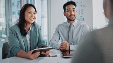 two project managers talk to a stakeholder.