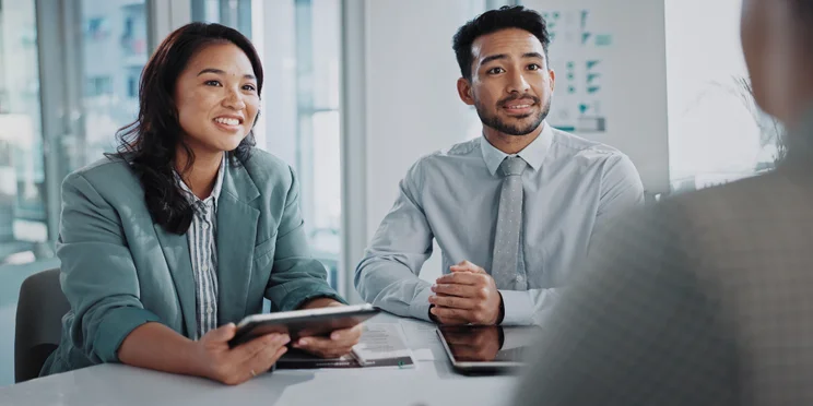 two project managers talk to a stakeholder.