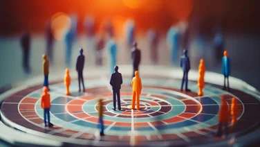 Little figures representing people stand on a segmented target