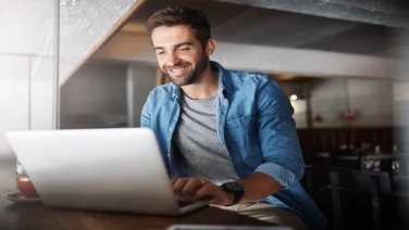 Remote worker smiling at laptop
