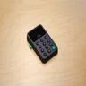 Black Zettle card reader with touchscreen display on wooden surface.