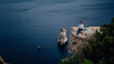 Person remote working on a cliff