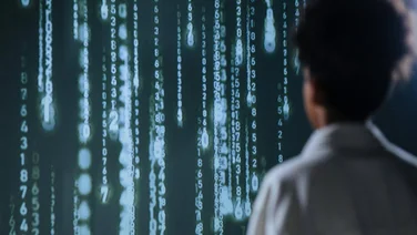A worker looks at a surreal cascading code, like in the Matrix