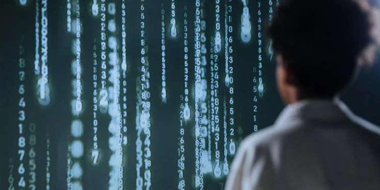 A worker looks at a surreal cascading code, like in the Matrix