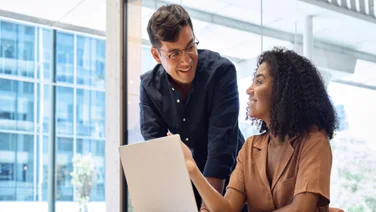 Colleagues smiling at each other and laptop