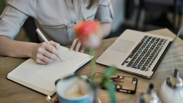A notebook and laptop are used for learning
