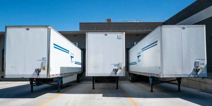 Three shipping containers in a lot
