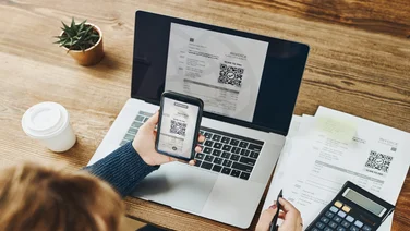 Person scanning QR code on invoice