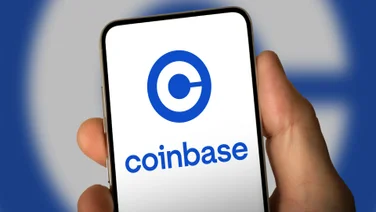 Person holding phone with Coinbase logo
