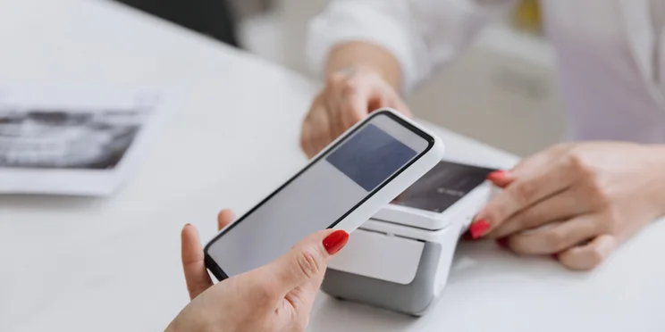 Someone paying with their phone on card reader