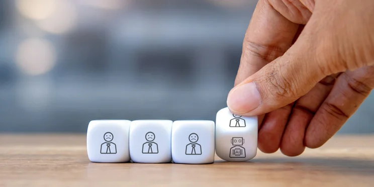 Hand turning over cube with humans and robots on either side