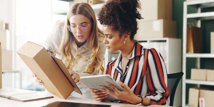 Colleagues looking at package and notes for ecommerce