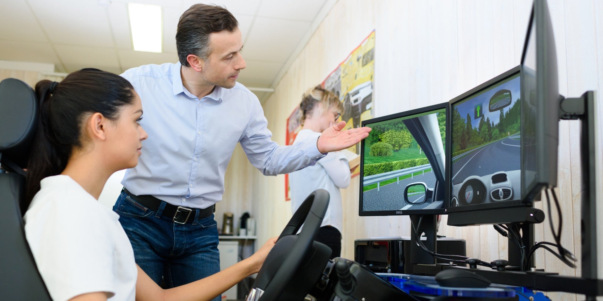 Teacher helping trainee driver on simulator