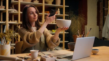 Woman taking picture of vase on phone