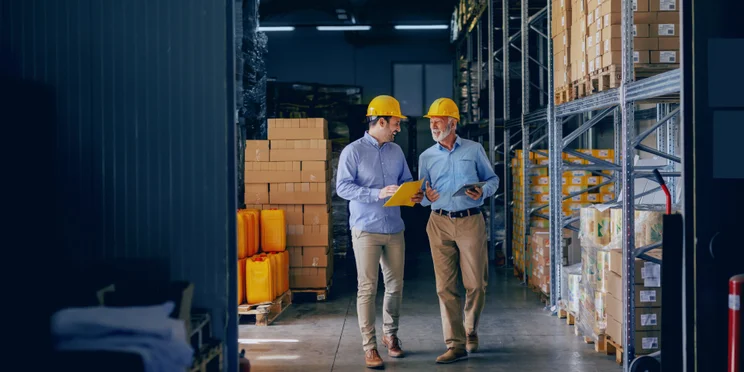 Men in helmets in delivery center in discussion