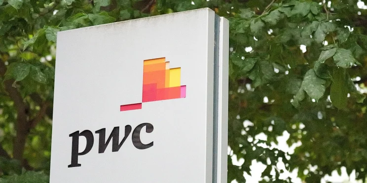 PwC logo on building side with trees