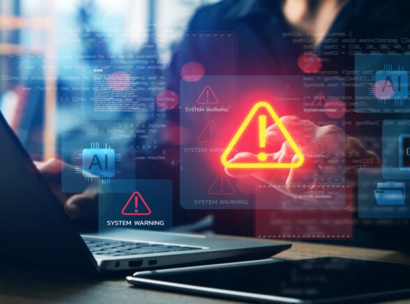 Person working at laptop with data breach on screen