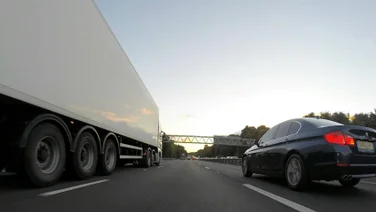 A truck on a road with a car