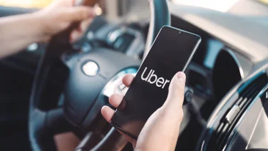 Uber logo on phone as someone drives