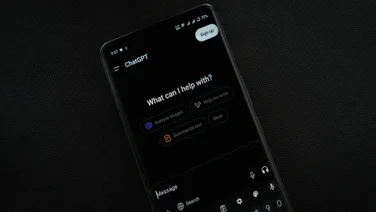 Phone on black background with ChatGPT open