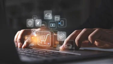 Person typing on laptop with ecommerce icons on screen