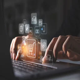 Person typing on laptop with ecommerce icons on screen